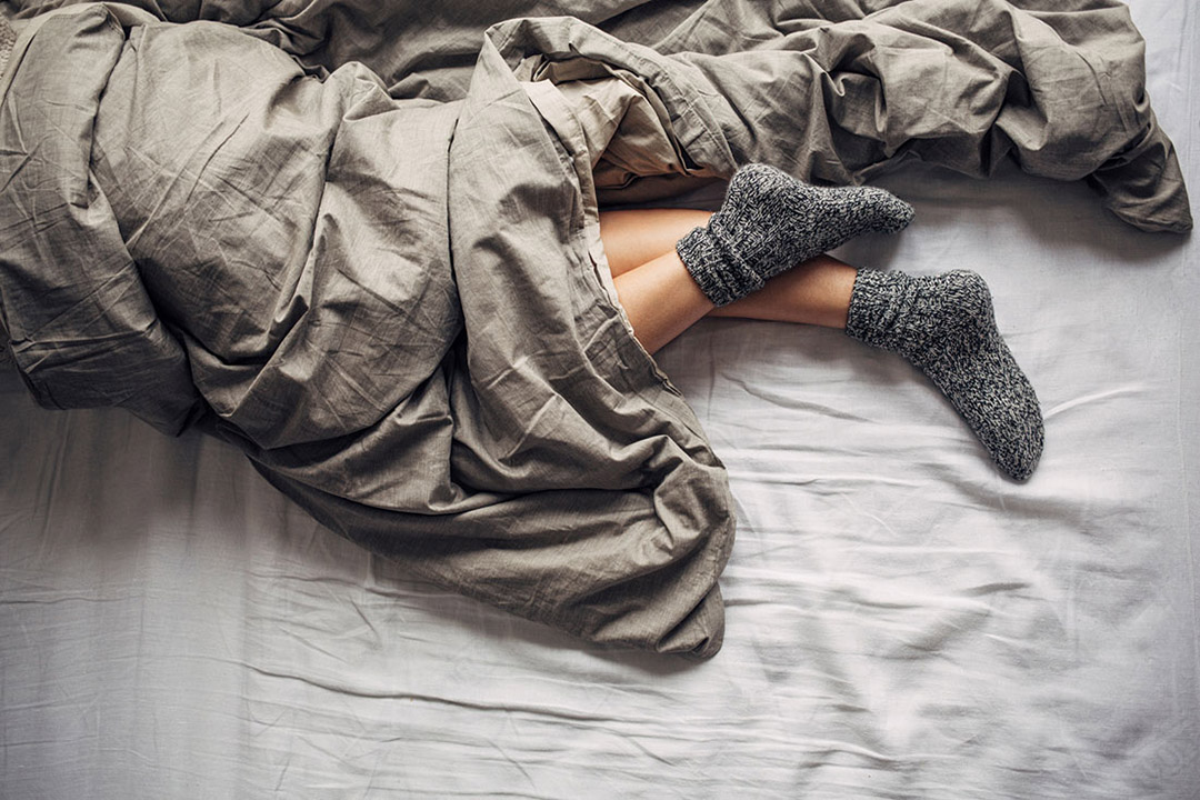 Woman Wearing Wool Socks Sleeping in Bed